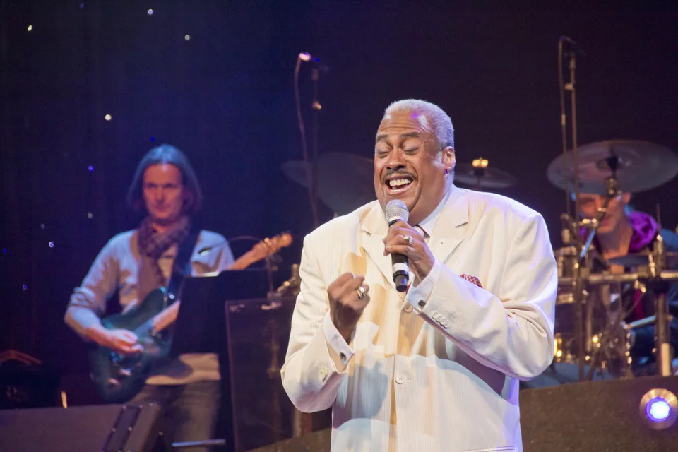 Keith singt im weißen Anzug, begleitet von seiner Band